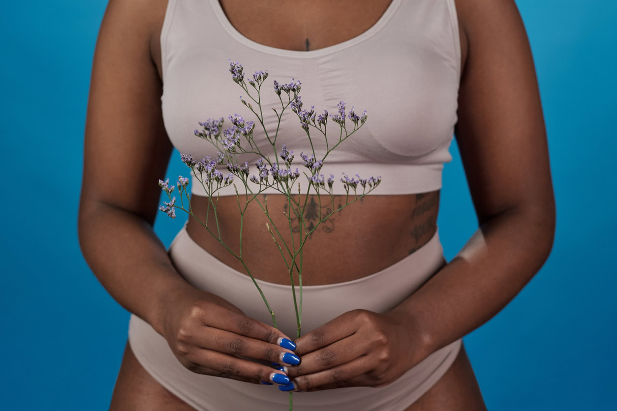 Young African female holding wildflower in front of herself