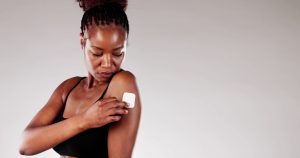 African American woman applying contraceptive patch