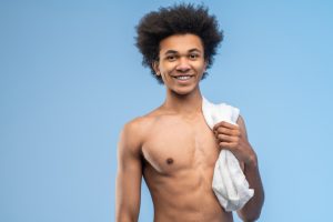Dark-haired young man with a towel on his shoulder